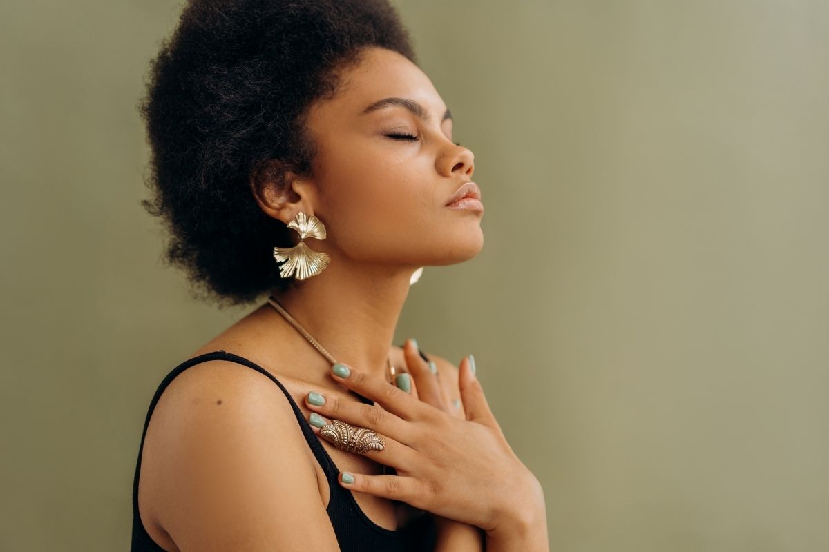 Woman in black spaghetti strap top meditating.