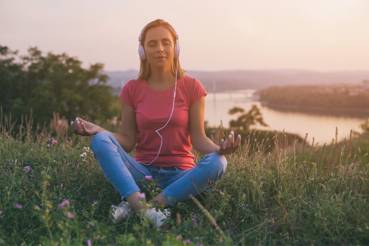 Woman enjoys meditating and listening music.