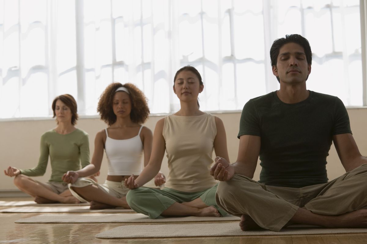 Group of people meditating in their respective mat.